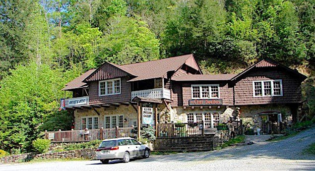 A car parked in front of a historic artists building on the side of a road.