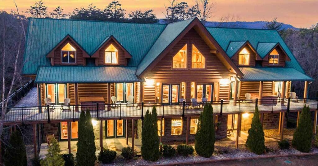 A large log home with a deck and patio area.