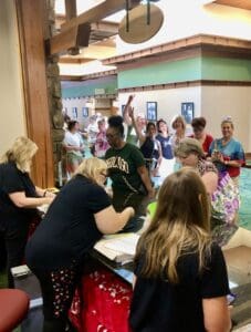 A group of people standing around a room.
