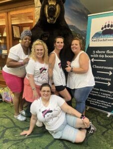 A group of women posing for a picture with a bear.