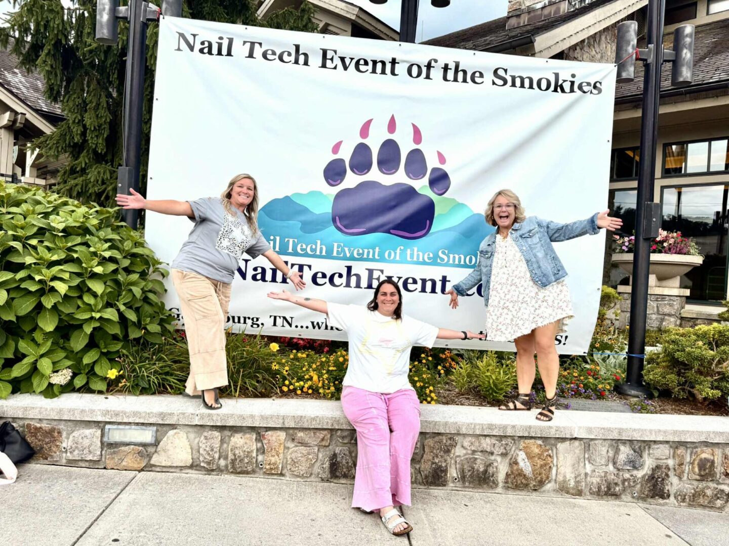 3 women standing in front of a huge banner