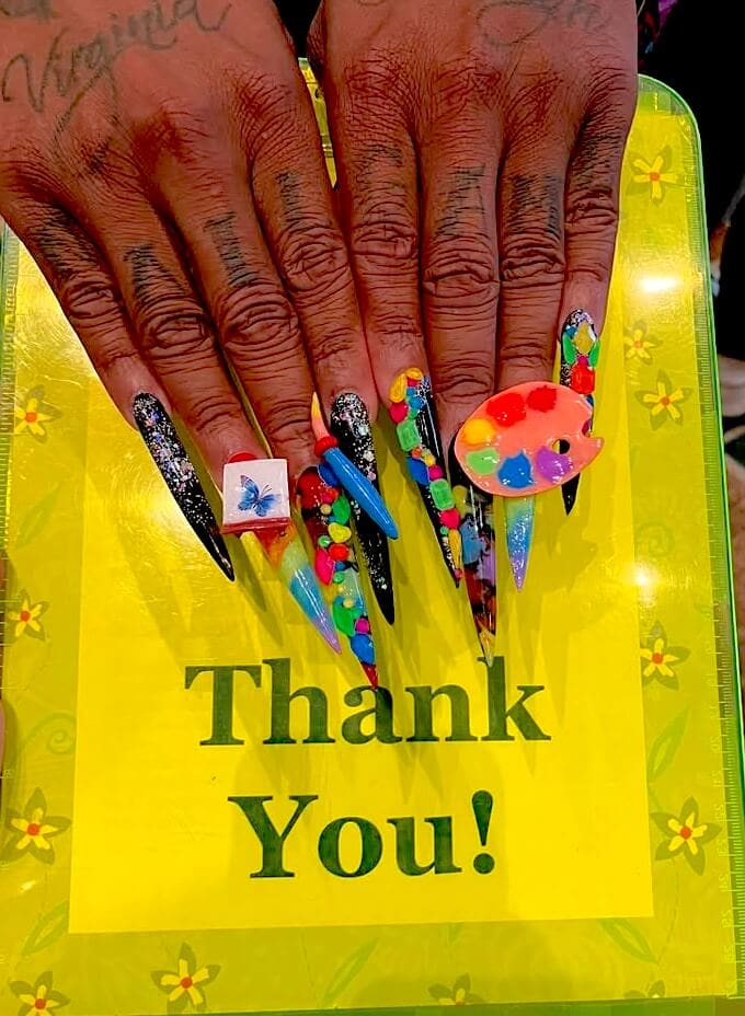long colorful fingernails on green board with words "thank you"